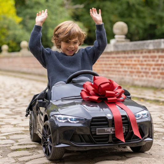 Kinderauto met een grote rode cadeaustrik